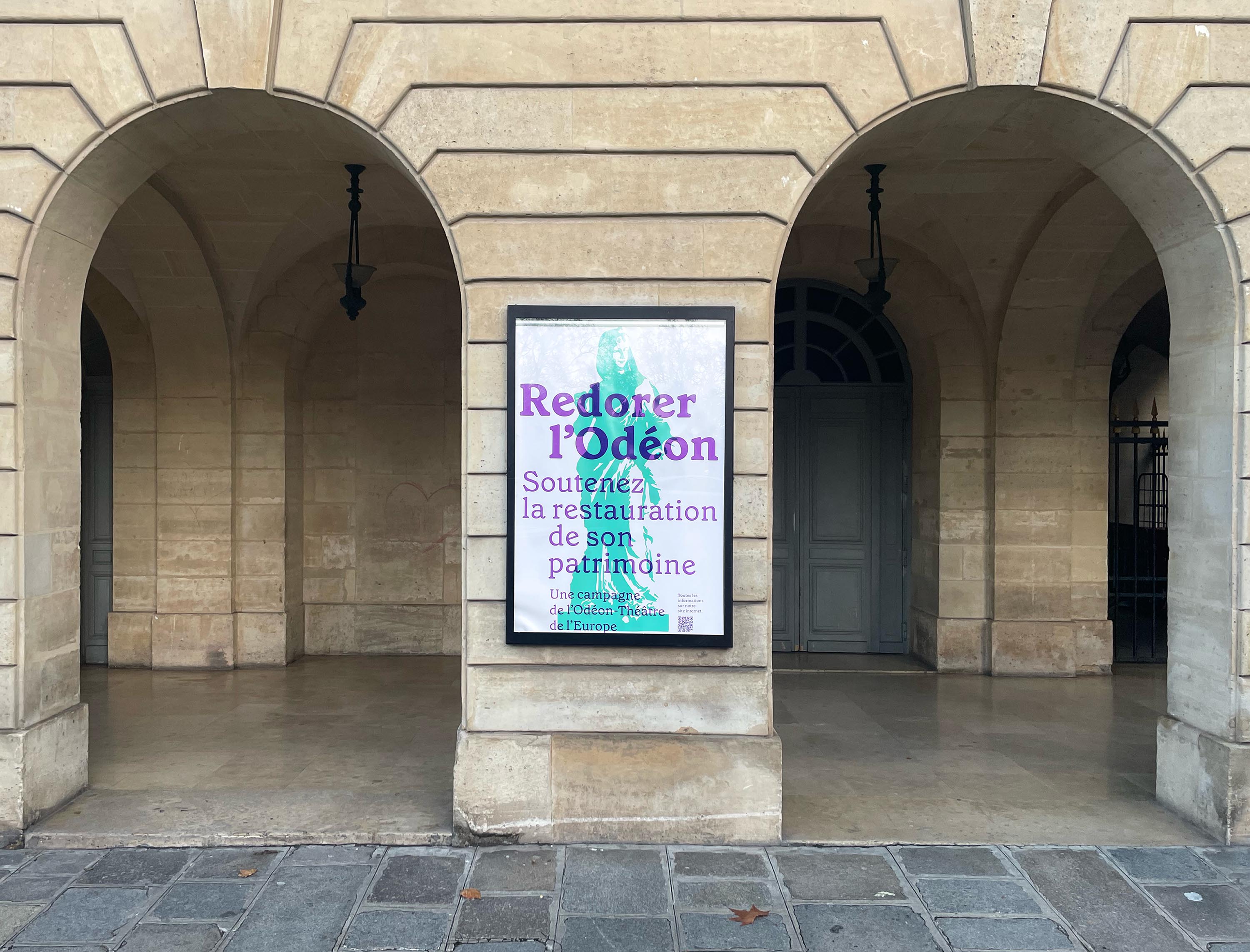 Vue de l’affiche “Redorer l’Odéon” à l'extérieur du théâtre.